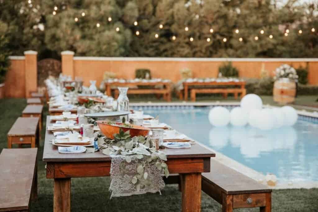 Backyard Wedding seating by a pool with white balloons in the middle. 