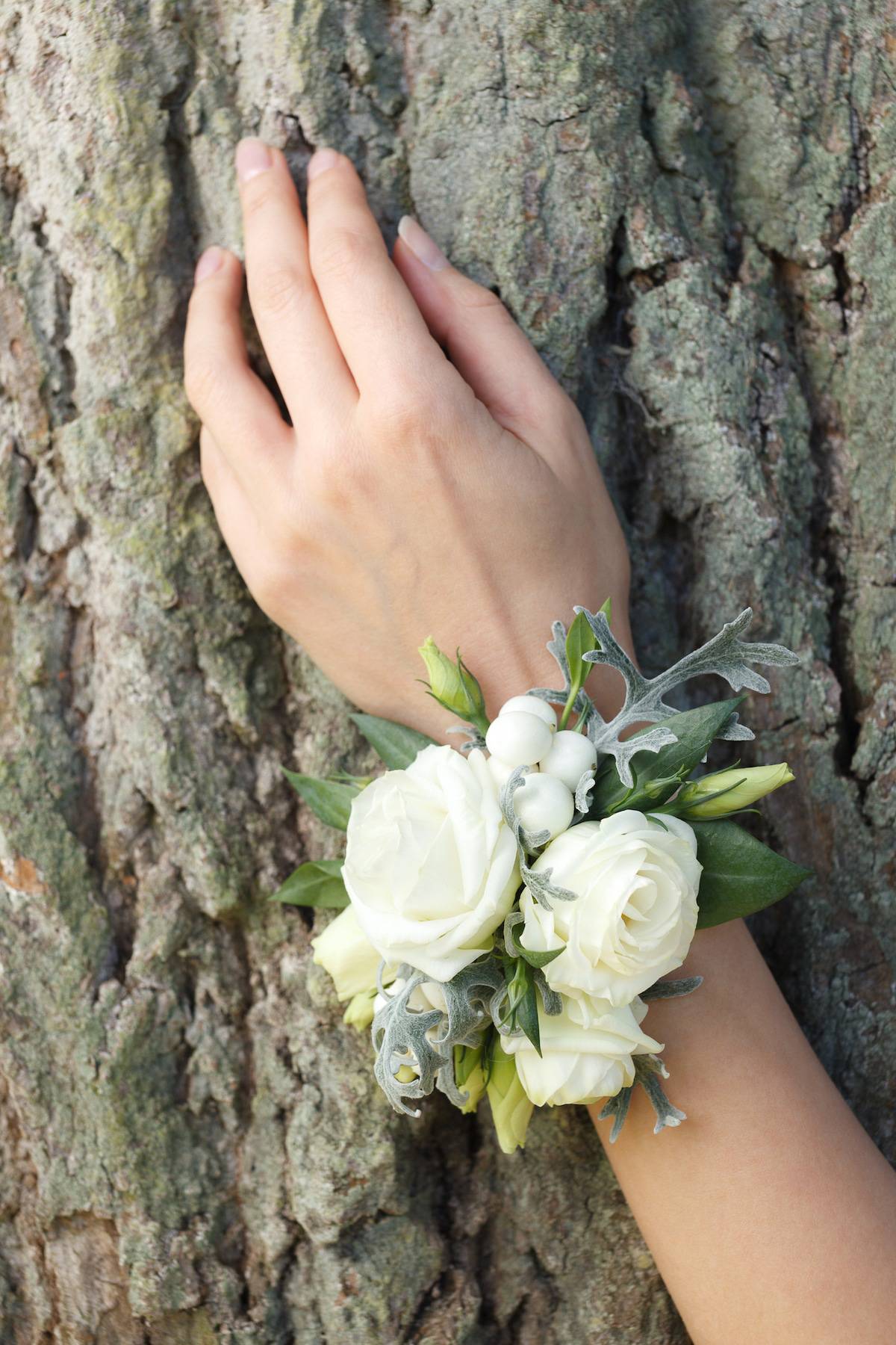 White and green wrist corsage on a hand