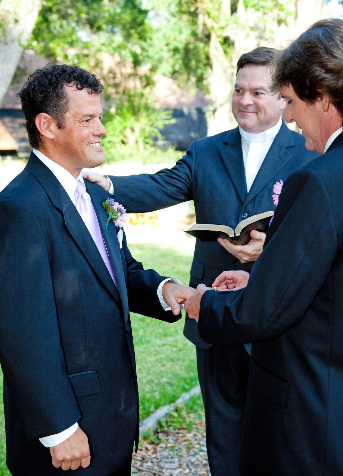 Groom slips a ring on his husband's finger during a gay marriage ceremony.