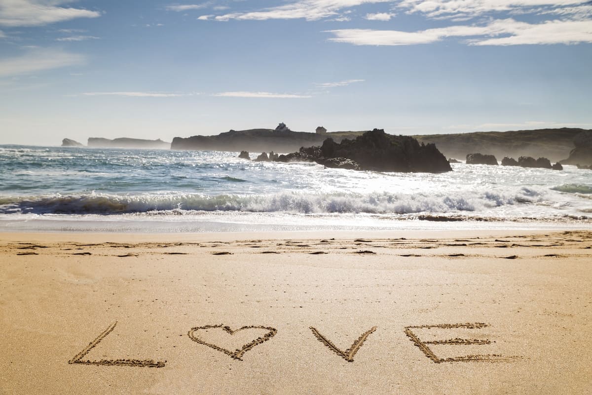 word love written in the sand of a beautiful beach