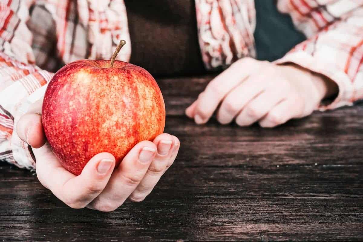 hand holding an apple.