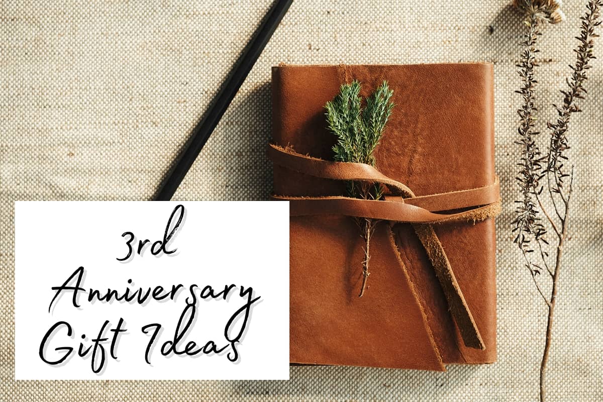 A leather journal, sprig of rosemary and a pencil with a sign saying 3rd anniversary gift ideas