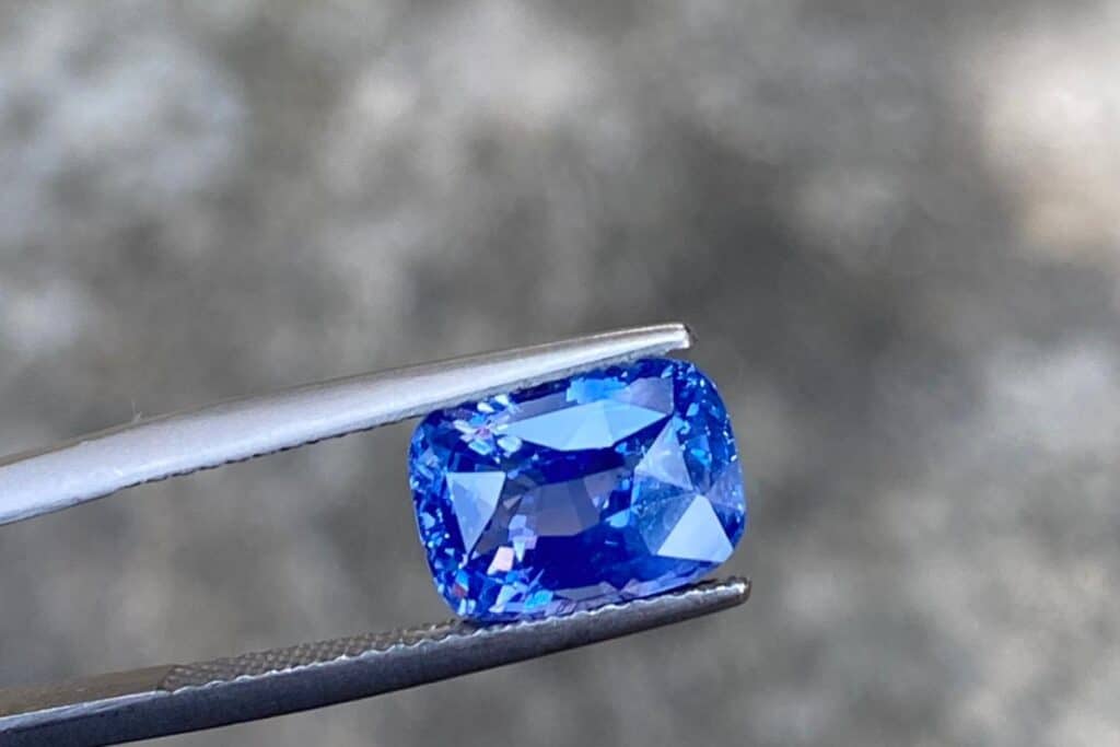Blue Sapphire Stone held in tweezers